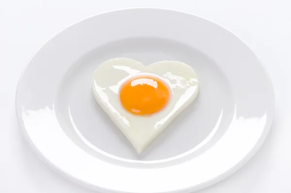 Heart shaped egg on a plate — Stock Photo, Image