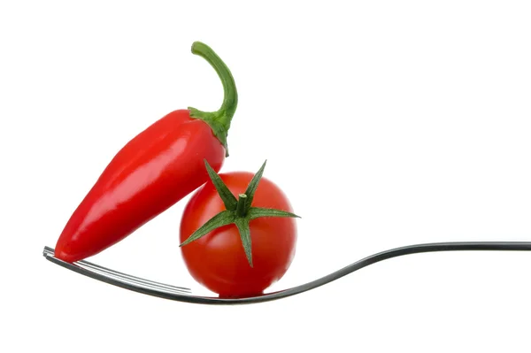 Chili pepper and tomato on a fork — Stock Photo, Image