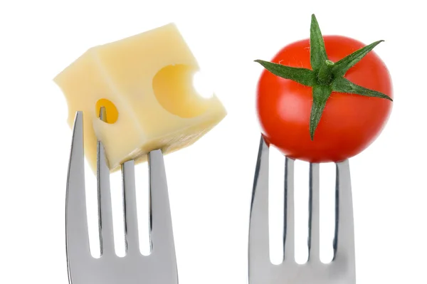 Cheese and tomato on forks against white — Stock Photo, Image