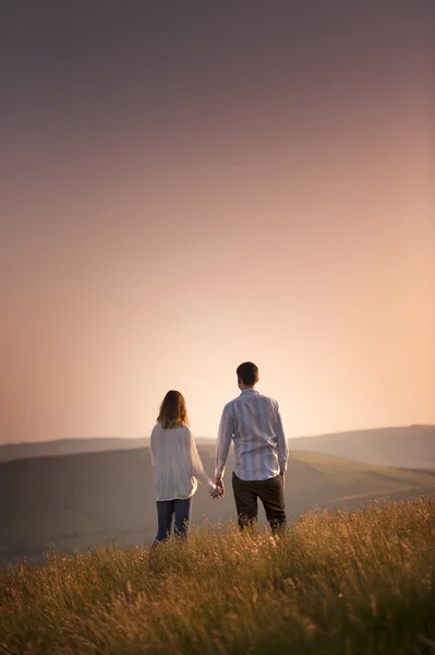 Casal assistindo o pôr do sol — Fotografia de Stock