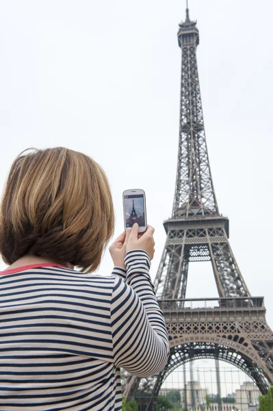 Woman taking photographs of eiffel tower paris using a cellphone — Stock Photo, Image