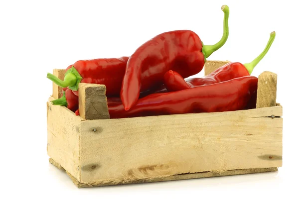 Fresh red sweet peppers (capsicum) in a wooden crate — Stock Photo, Image