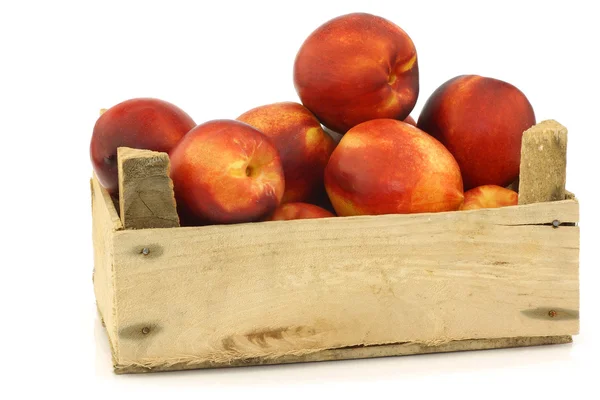 Verse nectarines in een houten krat — Stockfoto