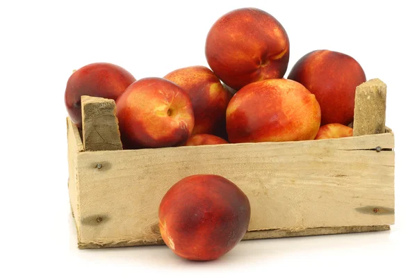 Fresh nectarines in a wooden crate — Stock Photo, Image