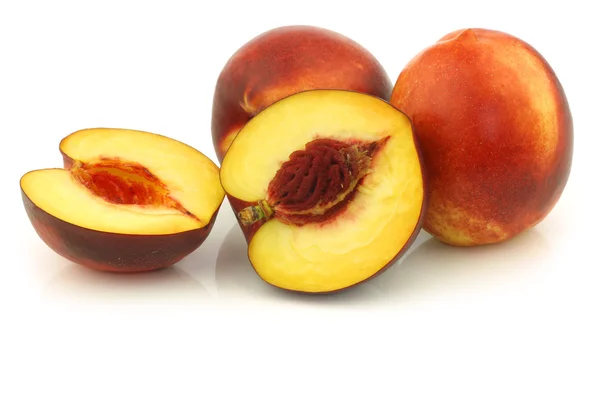 Fresh nectarines and a cut one — Stock Photo, Image