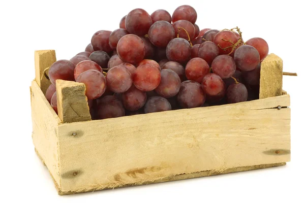 新鲜红无核葡萄在葡萄藤在木箱上 — 图库照片