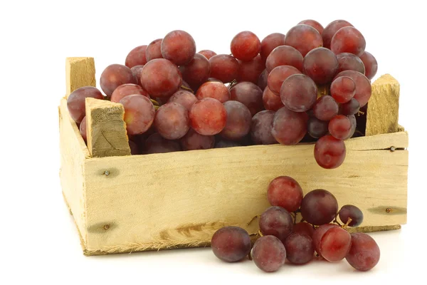 Свежий красный виноград на виноградной лозе в деревянном ящике — стоковое фото