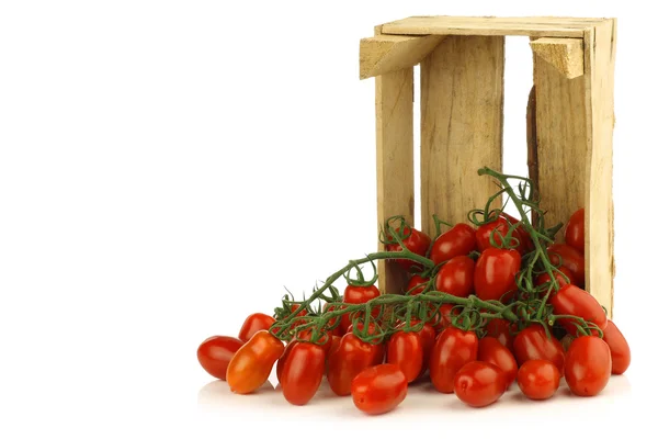 Frische italienische Kirschtomaten an der Rebe in einer Holzkiste — Stockfoto