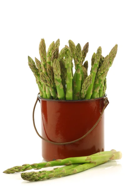 Fresh green asparagus shoots in a brown enamel cooking pot — Stock Photo, Image