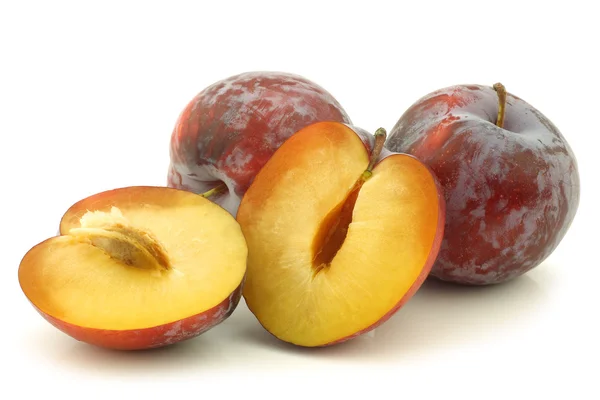 Fresh red plums and some pieces — Stock Photo, Image