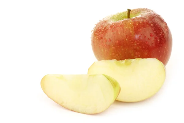 Jedno całe braeburn jabłko i niektóre kawałki — Zdjęcie stockowe