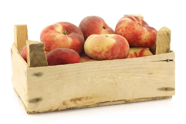 Fresh colorful flat peaches (donut peaches) in a wooden crate — Stock Photo, Image