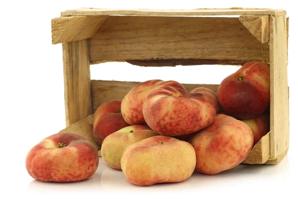 Fresh colorful flat peaches (donut peaches) in a wooden crate — Stock Photo, Image