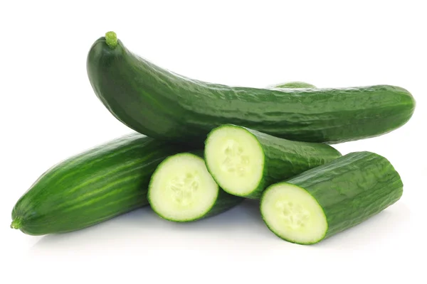 Verse komkommers en sommige stukken gesneden — Stockfoto