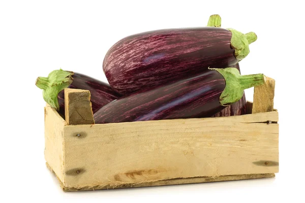 Gestreepte aubergines in een houten krat — Stockfoto