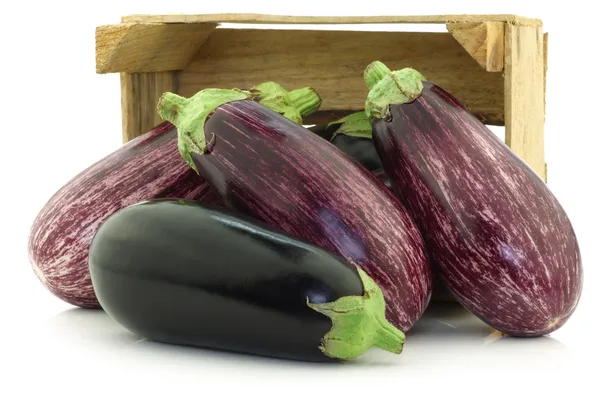 Mixed aubergines in a wooden crate — Stock Photo, Image