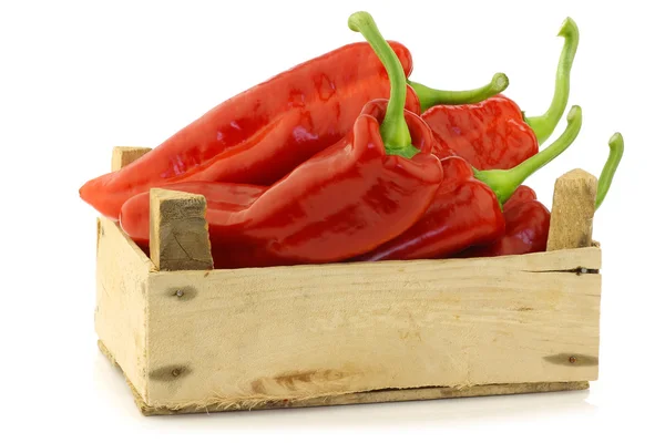 Fresh red sweet peppers (capsicum) in a wooden crate — Stock Photo, Image