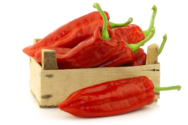 Verse rode scherpsmakende pepers (paprika) in een houten krat — Stockfoto