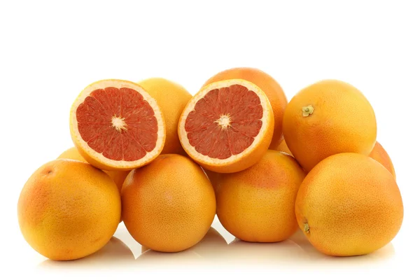 Fresh red grapefruits and a cut one — Stock Photo, Image