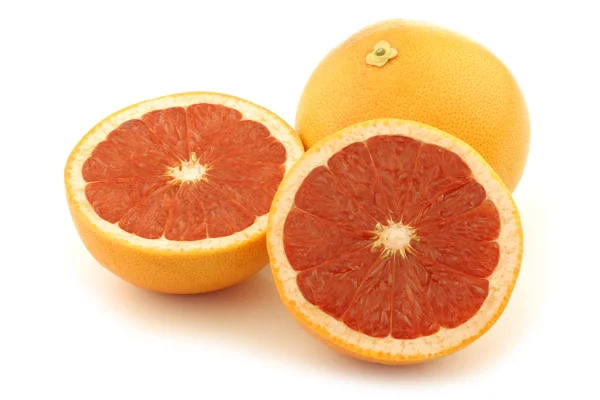 Fresh red grapefruit and a cut one — Stock Photo, Image