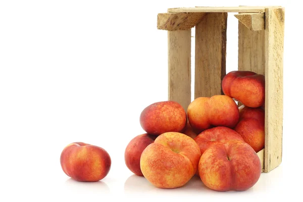 Fresh wild (flat) nectarines in a wooden crate — Stock Photo, Image