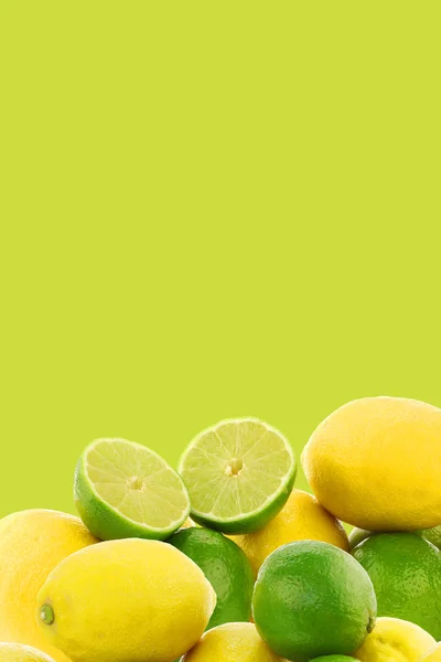 Frisch geschnittene Limettenfrüchte und Zitronen auf grünem Hintergrund — Stockfoto