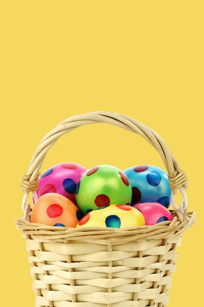 Colorful easter eggs in a wicker basket — Stock Photo, Image