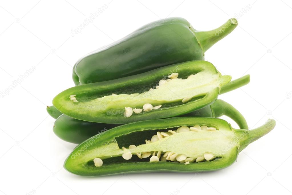 Fresh green peppers and a cut one (capsicum)