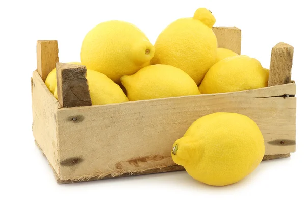 Fresh lemons and a cut half in a wooden crate — Stock Photo, Image