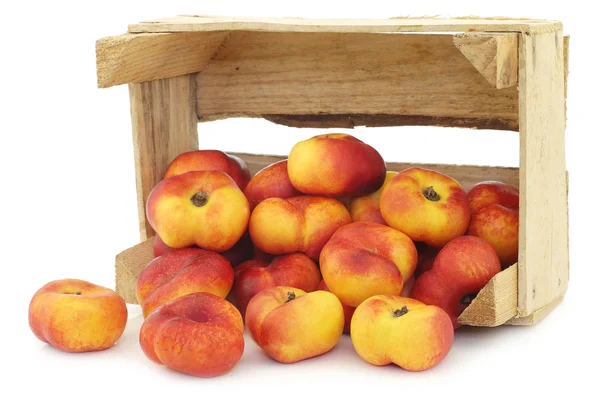 Nectarinas planas en una caja de madera —  Fotos de Stock