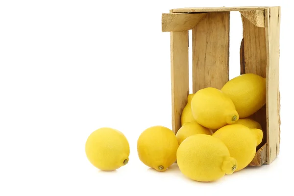 Fresh lemons and a cut half in a wooden crate — Stock Photo, Image