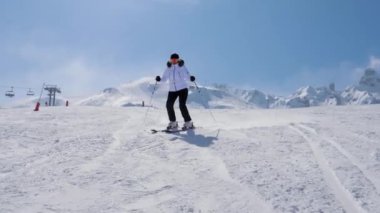 Kayakçı, kışın dağlarda kayak yaparken kayak yaparak yamaçtan kayar.