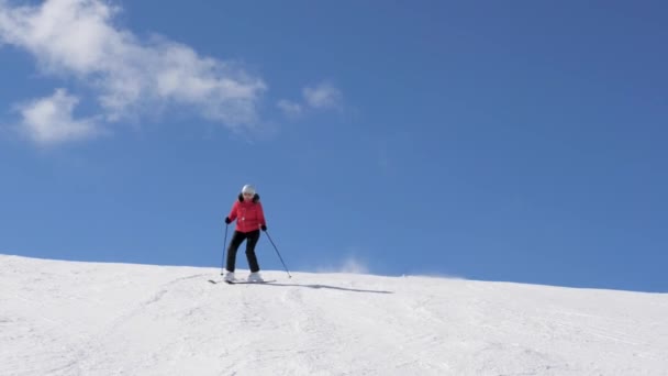 Skifahrer rutscht Slalom auf schneebedecktem Hang in den Bergen im Winter auf Skiern herunter — Stockvideo