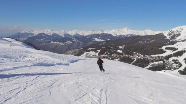 Slalomy narciarzy w dół Śnieżnego zbocza w górach — Wideo stockowe