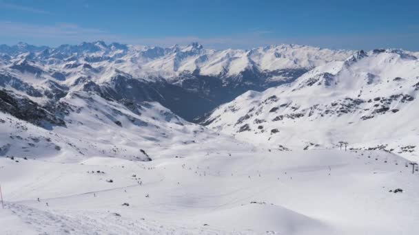 Wielu narciarzy i snowboardzistów jeździ na nartach na stoku w ośrodku narciarskim Góry — Wideo stockowe
