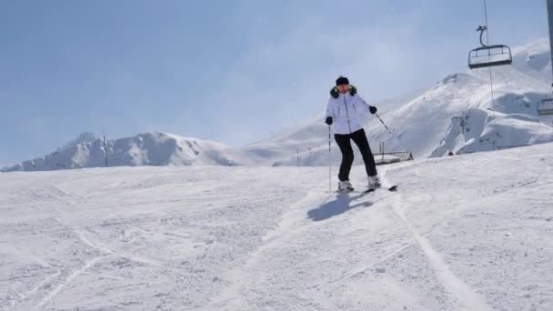 Skiër skiën op de besneeuwde piste in de bergen in de winter op ski in beweging — Stockvideo