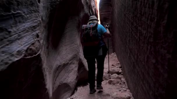 Turista caminhante com mochila andando no estreito desfiladeiro da caverna — Vídeo de Stock