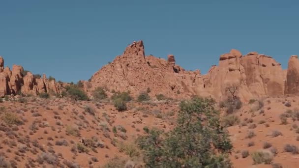 Κόκκινος πορτοκαλί μονολιθικός σχηματισμός πετρωμάτων σε ξηρή έρημο την ηλιόλουστη ημέρα σε κίνηση — Αρχείο Βίντεο