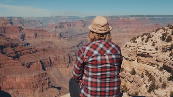 Touriste se trouve sur la falaise du Grand Canyon et bénéficie d'une vue imprenable — Video