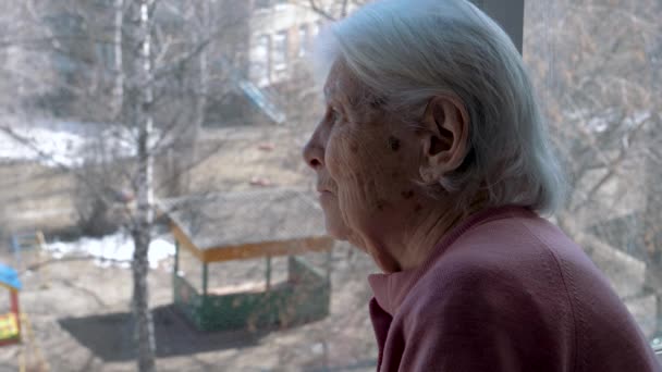 Staré starší 80. léta 90. let běloška Neplatná dívá se smutně z okna na ulici — Stock video