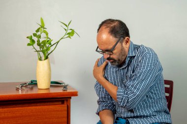 Omuz ağrısı olan yaşlı bir adam. Orta yaşlı beyefendi çok acı çekiyor. Boyun ve omuz ağrısı. Boyun ve omuz yaralanması. Sağlık sorunu olan biri.
