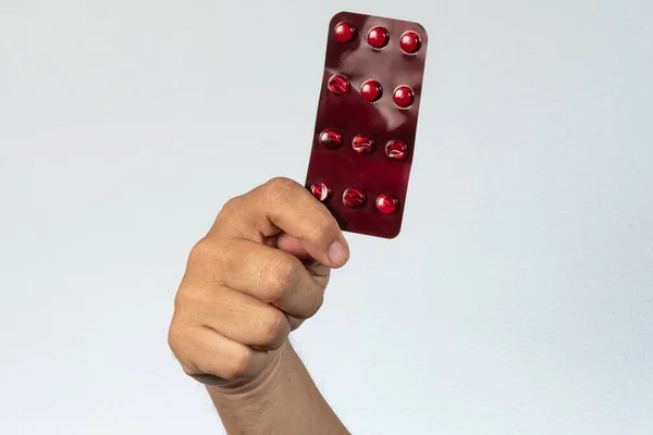 Mão Segurando Medicamento Bolha Vermelha Fundo Cinza — Fotografia de Stock