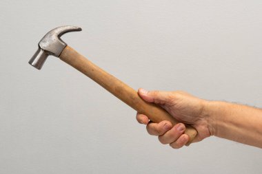 Adamın eli gri arkaplanda izole edilmiş bir araç tutuyor.