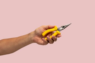 Adamın eli pembe arkaplanda izole edilmiş bir araç tutuyor.