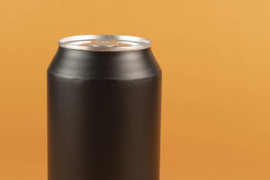 Siyah alüminyum teneke kutu turuncu arkaplanda izole