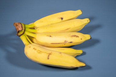 Mavi arka planda olgun gümüş muz demeti