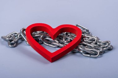 Mavi bir zemin etrafında metalik zincir olan kalp şekli