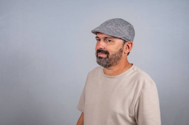 Çekici, olgun bir adamın portresi. Gri arka planda izole edilmiş bej gömlek giyen gerçek mutlu duygular hisset.