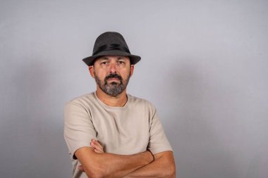 Çekici, olgun bir adamın portresi. Gri arka planda izole edilmiş bej gömlek giyen gerçek mutlu duygular hisset.