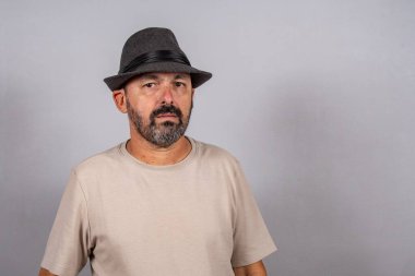 Çekici, olgun bir adamın portresi. Gri arka planda izole edilmiş bej gömlek giyen gerçek mutlu duygular hisset.